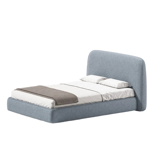 A modern low-profile platform bed with a tall upholstered headboard, upholstered in a textured light blue-gray fabric. The bed is styled with white bedding, two white pillows, and a brown throw blanket, set against a plain light gray background.